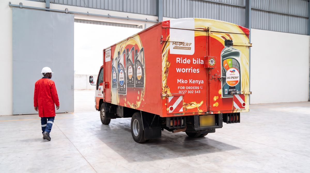 Generated image: a red delivery truck in MKO colours at an open loading door, with a worker in red overalls walking beside it.